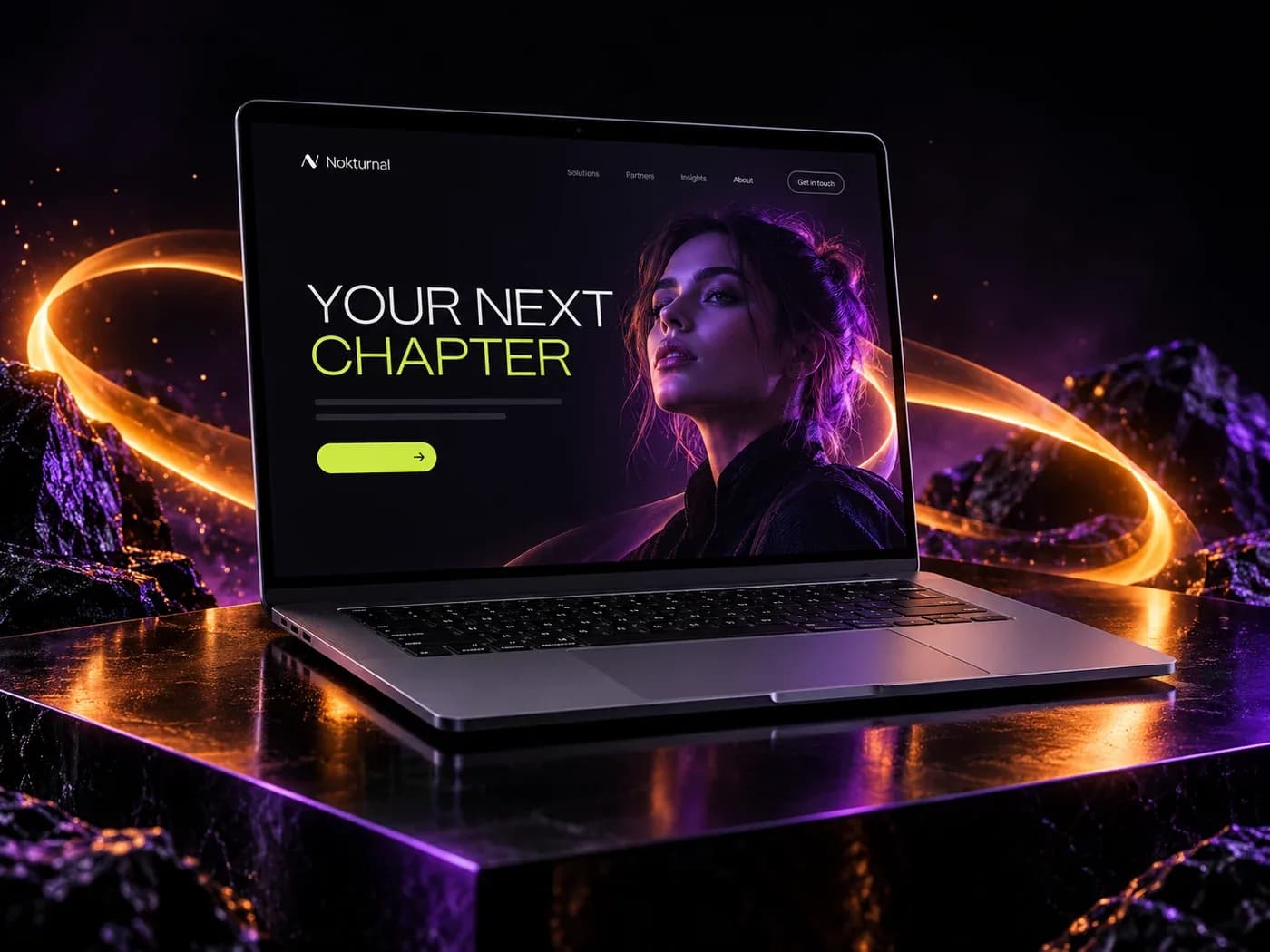 A graphite laptop displaying a Nokturnal website concept, surrounded by orange and violet light trails